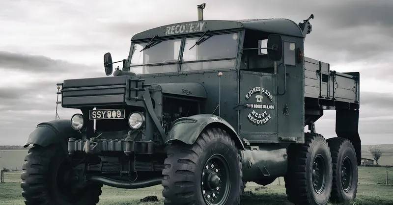 A historic military recovery truck parked in a countryside setting, showcasing its vintage charm.