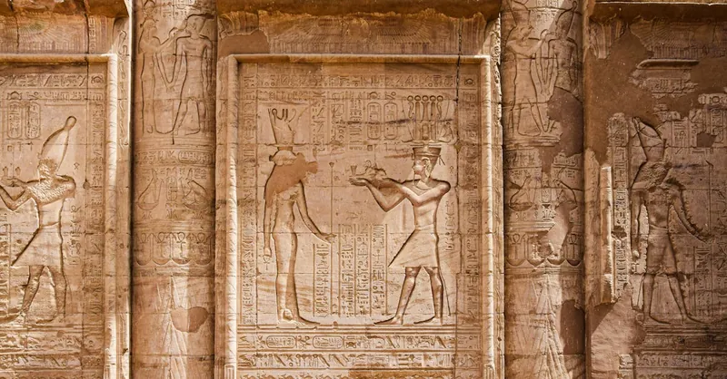 Engraved stone reliefs with intricate hieroglyphs from ancient Egyptian civilization.