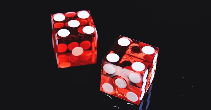Close-up of two red dice on black surface, symbolizing chance and luck.