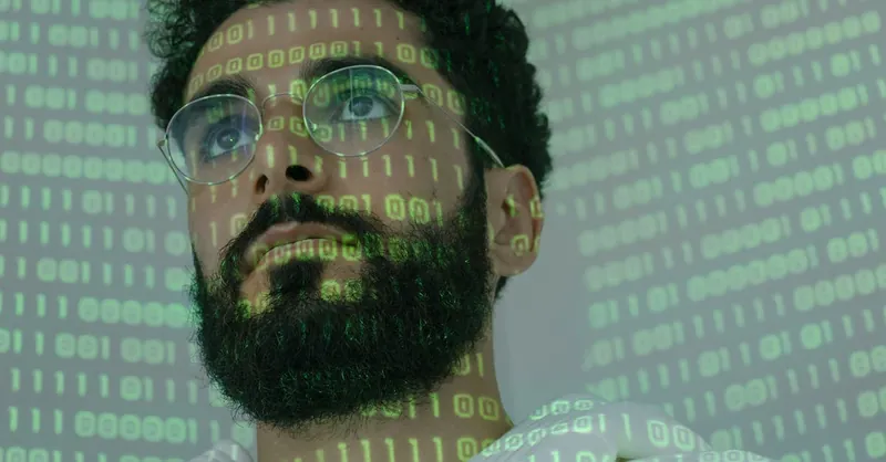 Close-up of a man with glasses and binary code projection, symbolizing cyber security.