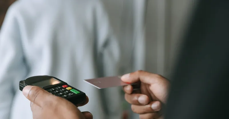 Close-up of a contactless payment with a card and POS terminal, showcasing secure electronic transactions.